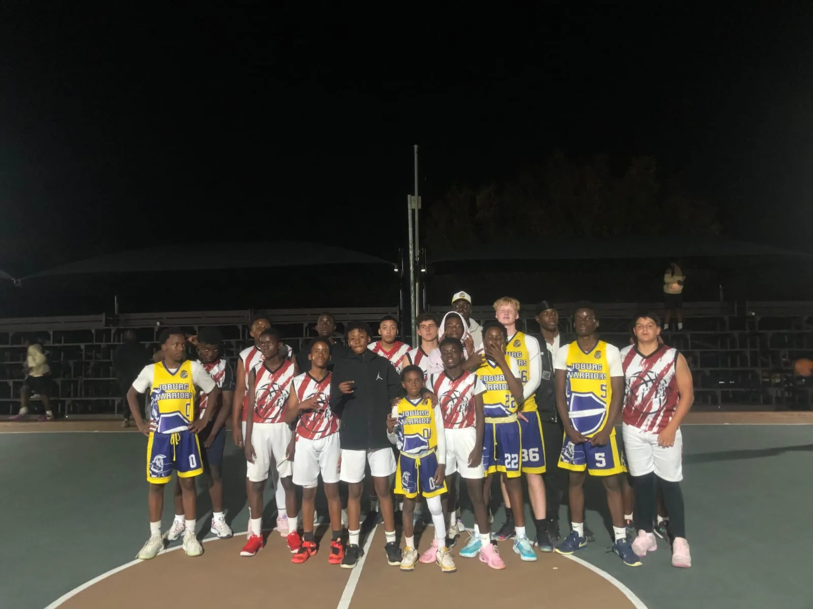 Joburg Warriors boys and their opponents together on court after a night game