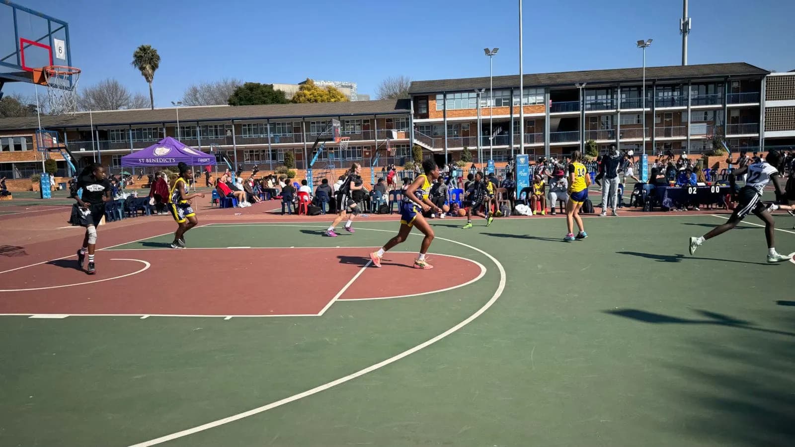 A Warriors game in action on an outdoor court on a sunny day